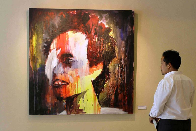 Seorang pengnjung tengah memperhatikan karya lukis Patrick Wowor yang dipamerkan di pameran tunggalnya bertema Underexposed di Galeri 3, Taman Ismail Marzuki - Jakarta. 